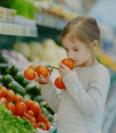 little-girl-smelling-tomatoes